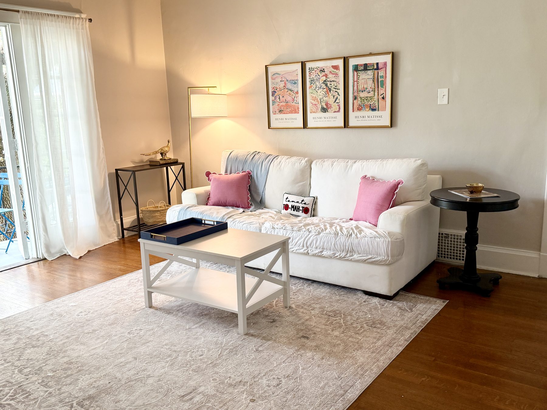 Living room with a white slip-covered sofa and framed botanical prints