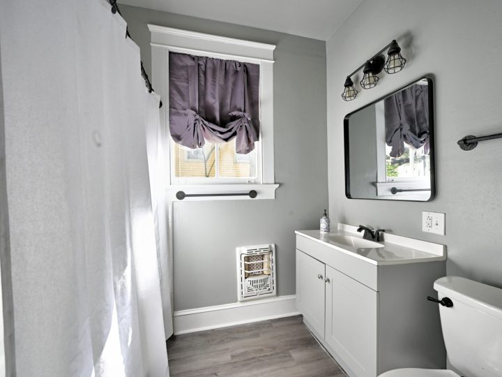 Full bathroom with a vanity, mirror and window