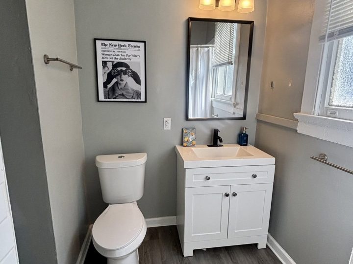 Bathroom with a vanity, sconce lighting and framed art