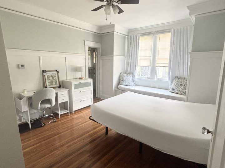 Bedroom with a ceiling fan and painted wainscoting