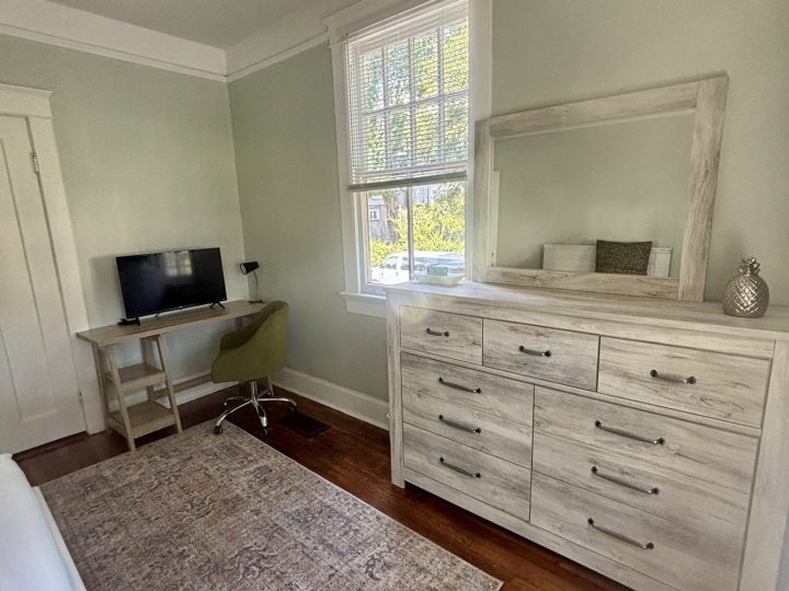 Bedroom with a dresser, mirror and television