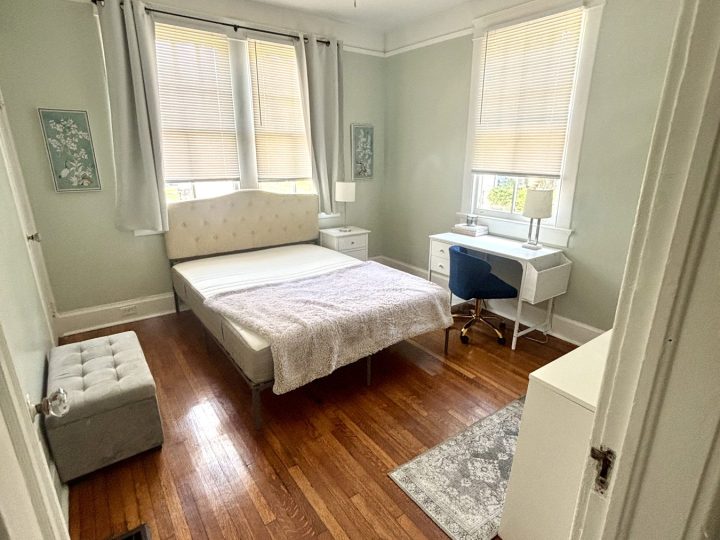Bedroom with a bed, desk and paired windows