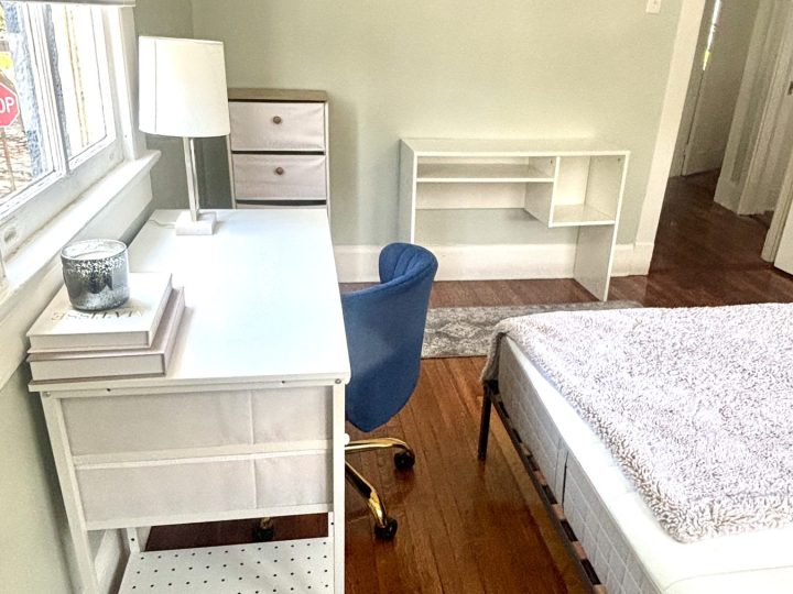 Bedroom desk nook with a white writing desk and shelf