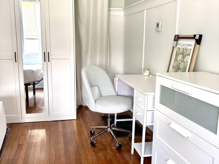 Bedroom with closet doors, a desk chair and dresser