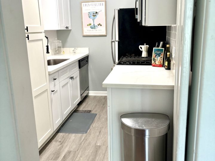 Galley kitchen with white cabinetry and quartz counters
