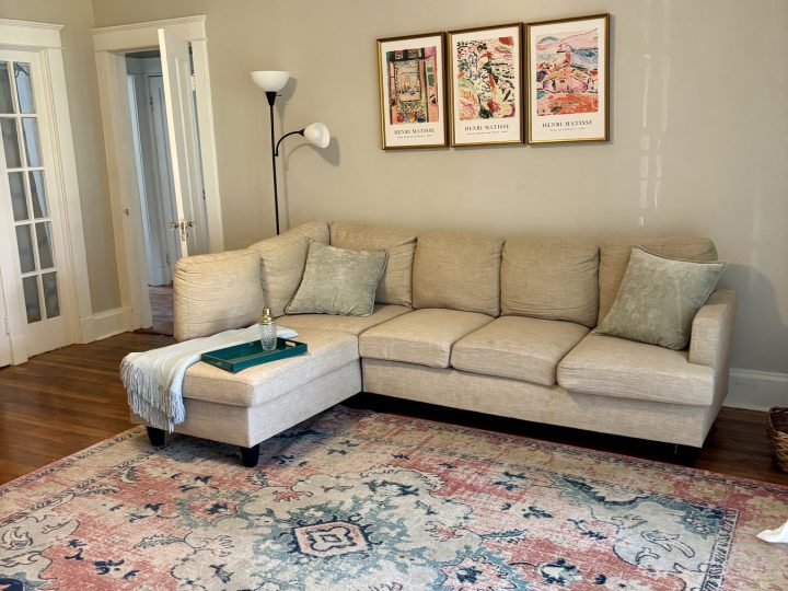 Living room with a sectional sofa, patterned rug and framed prints