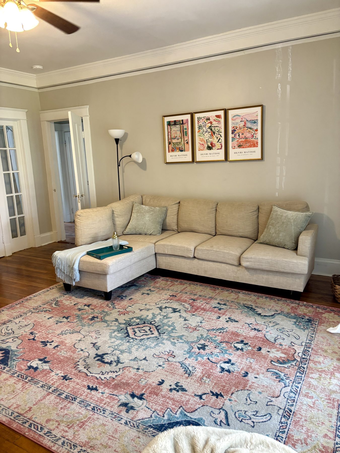 Living room with a sectional sofa, patterned rug and framed prints