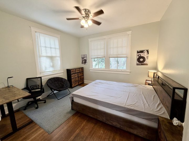 Bedroom with a desk, lounge chair and hardwood floors