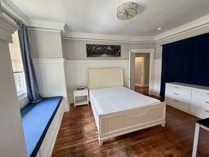 Primary bedroom with a large window seat and blue accents