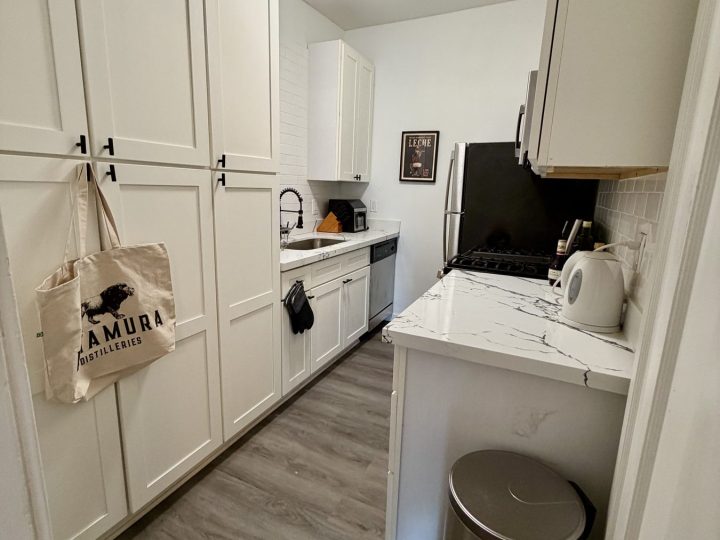 Kitchen with tall storage cabinets, quartz counters and electric kettle