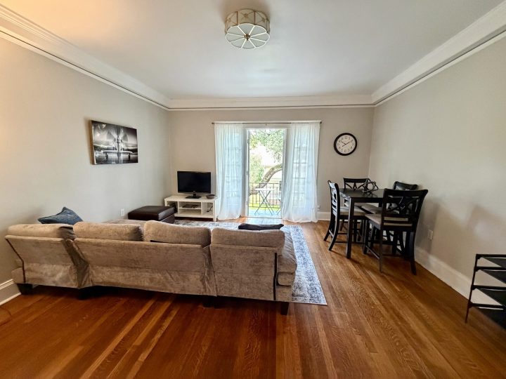 Living and dining area with hardwood floors and high ceilings